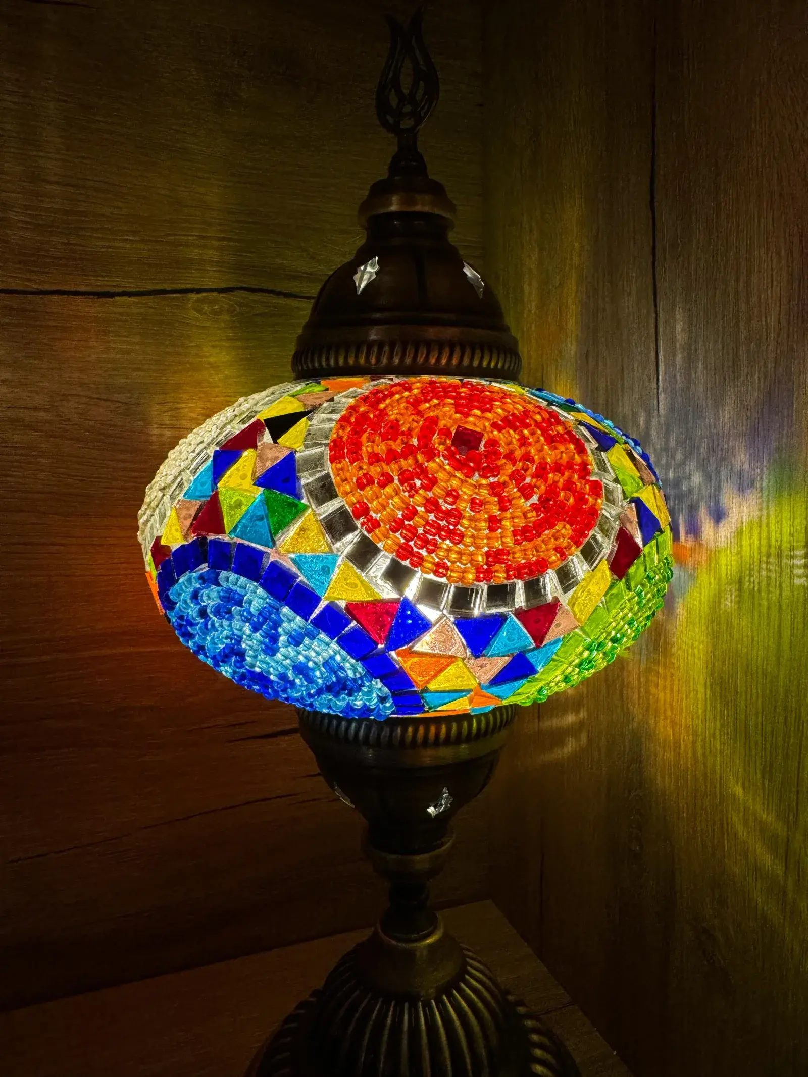 Two-tone red and blue mosaic lamp casting jewel-toned light, made in our Balat workshop