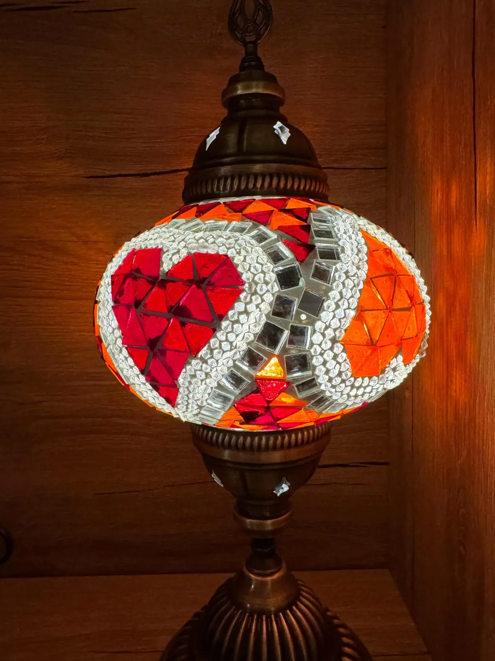 Turquoise and ruby mosaic lamp casting patterned light at our Balat studio in Istanbul
