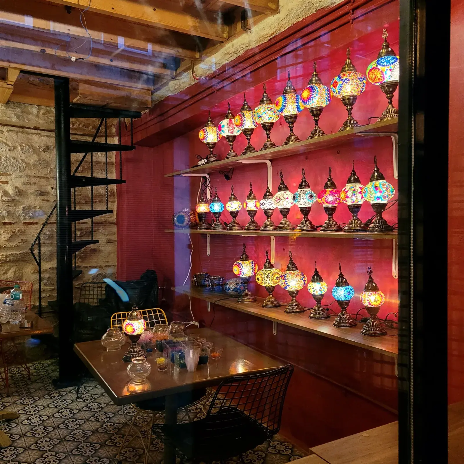 Interior of Glow Balat studio in Balat, Istanbul — stone walls and a full wall of glowing mosaic lamps