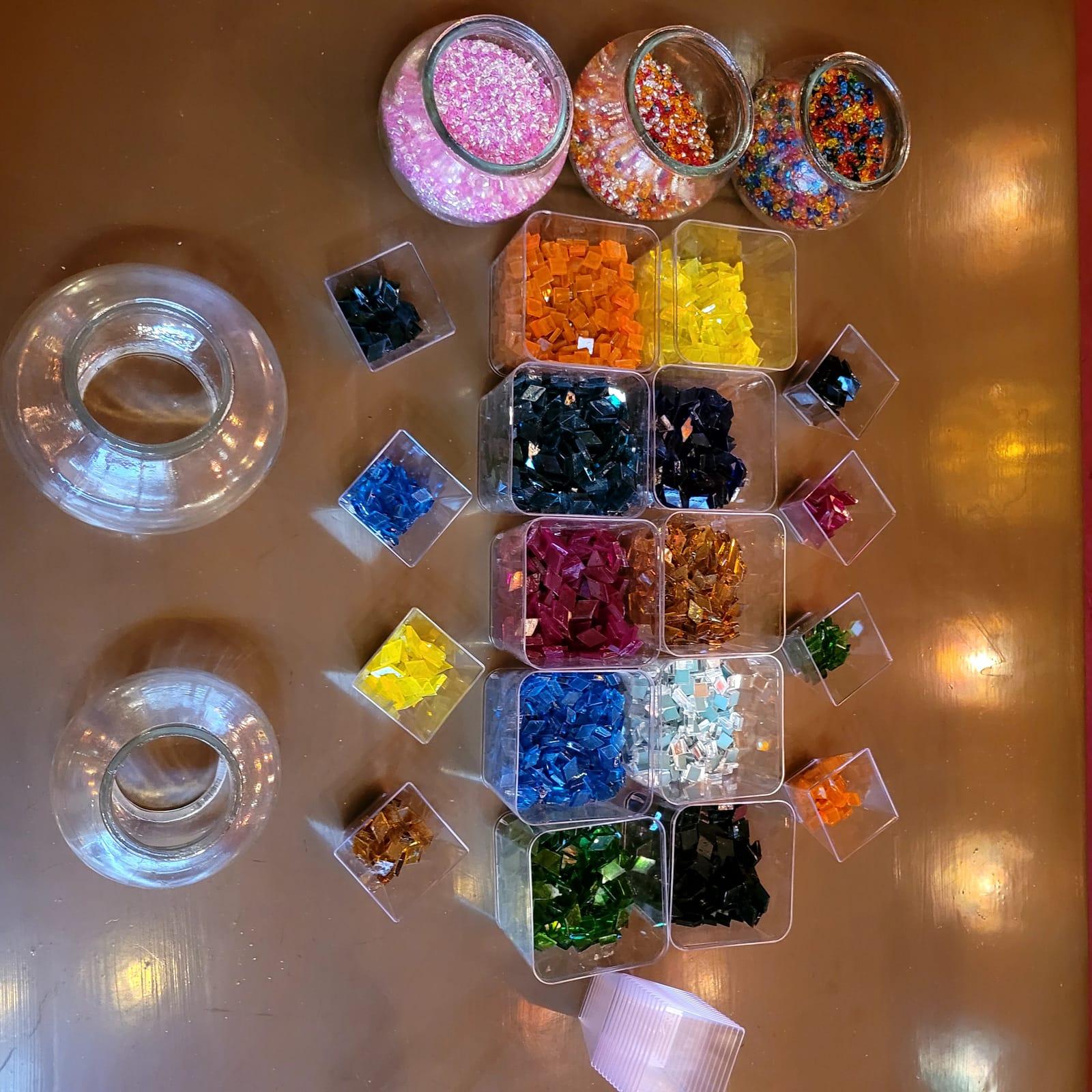 Trays of coloured glass tiles sorted by hue on the workshop table