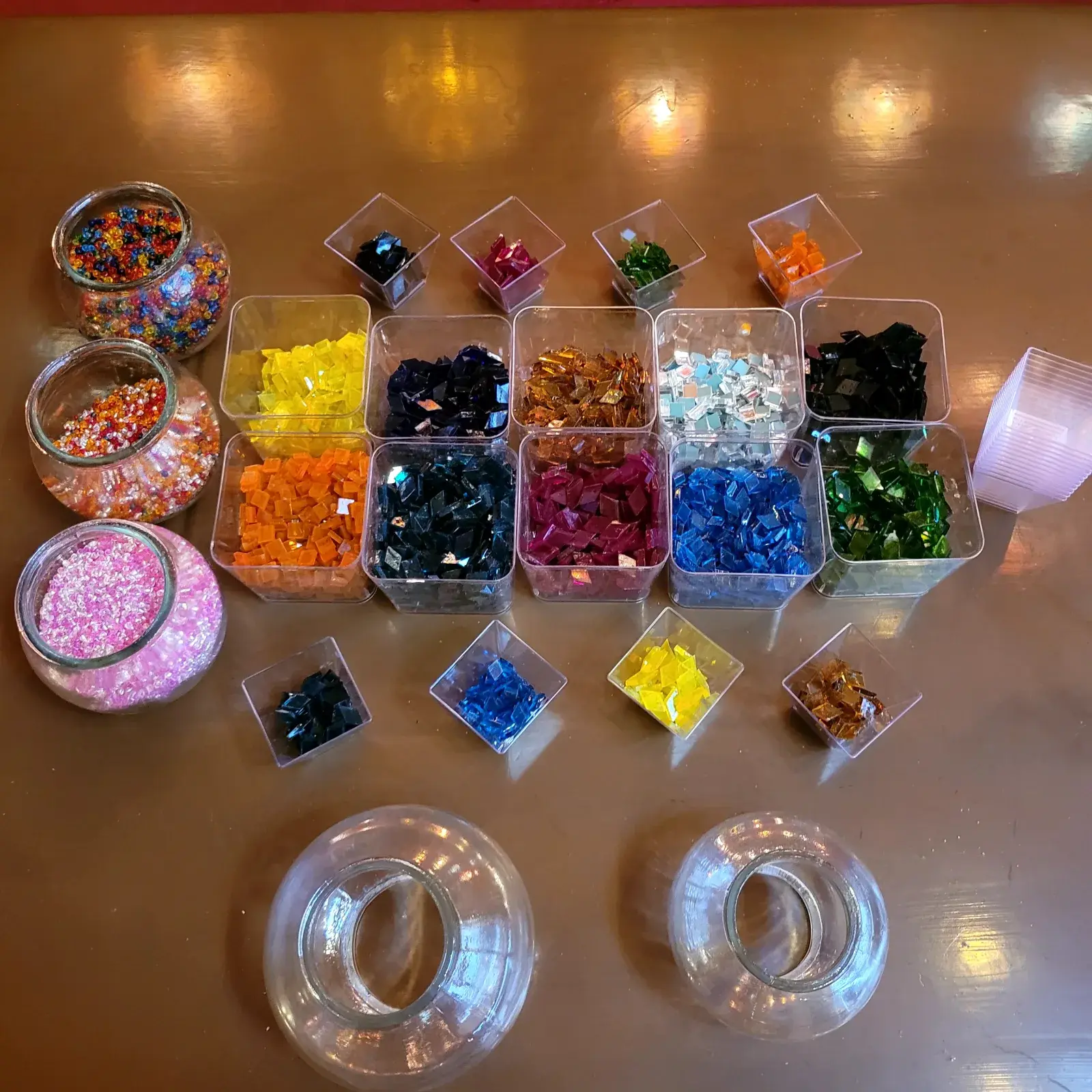 Trays of coloured glass tiles sorted by hue on the workshop table at our Balat studio