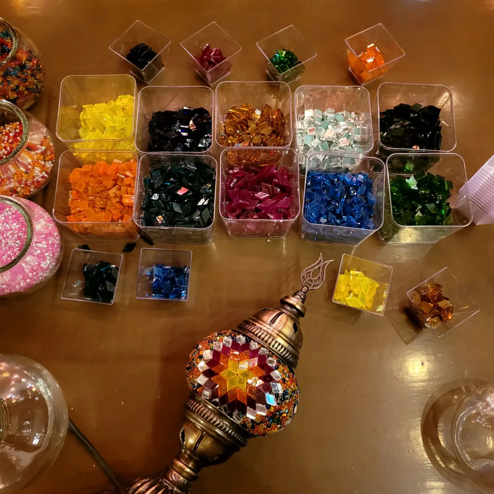 Overhead view of the workshop table in Balat with glass tesserae and a mosaic lamp in progress