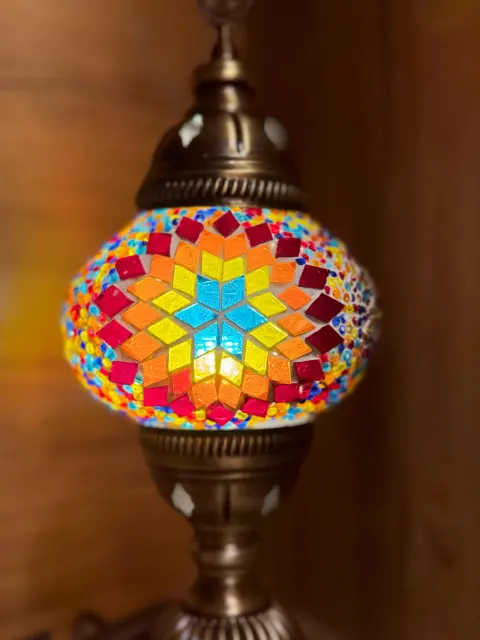 A lit lamp with a star in red, yellow and turquoise