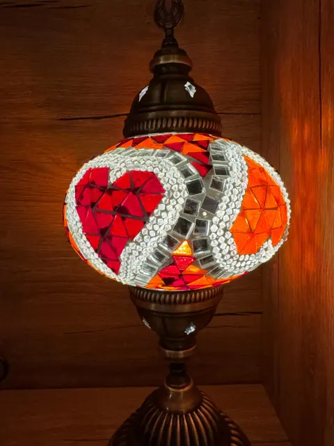 A lit lamp with a red heart pattern